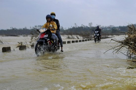 Người dân liều mình đi qua cầu tràn ngập lũ