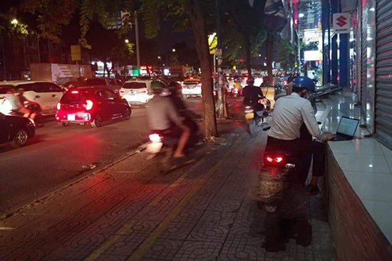 Thanh niên dừng xe trên vỉa hè, tranh thủ làm báo cáo bên dòng người đi countdown: Đúng là deadline không chừa một ai!