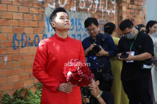 Hình ảnh lạ lẫm của thiếu gia Phan Thành trong chiếc áo dài đỏ, đăm chiêu đứng giữa ngõ cầm hoa cưới ngóng cô dâu Primmy Trương