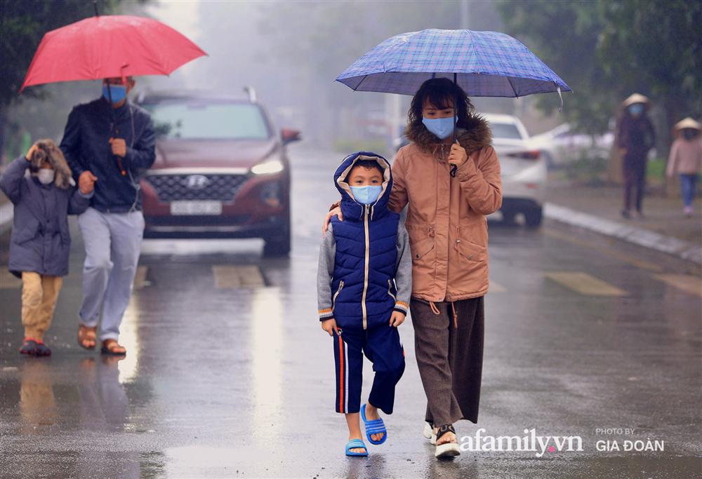 Ảnh: Cha mẹ học sinh trường Tiểu học Xuân Phương đội mưa đưa con đi xét nghiệm COVID-19-1