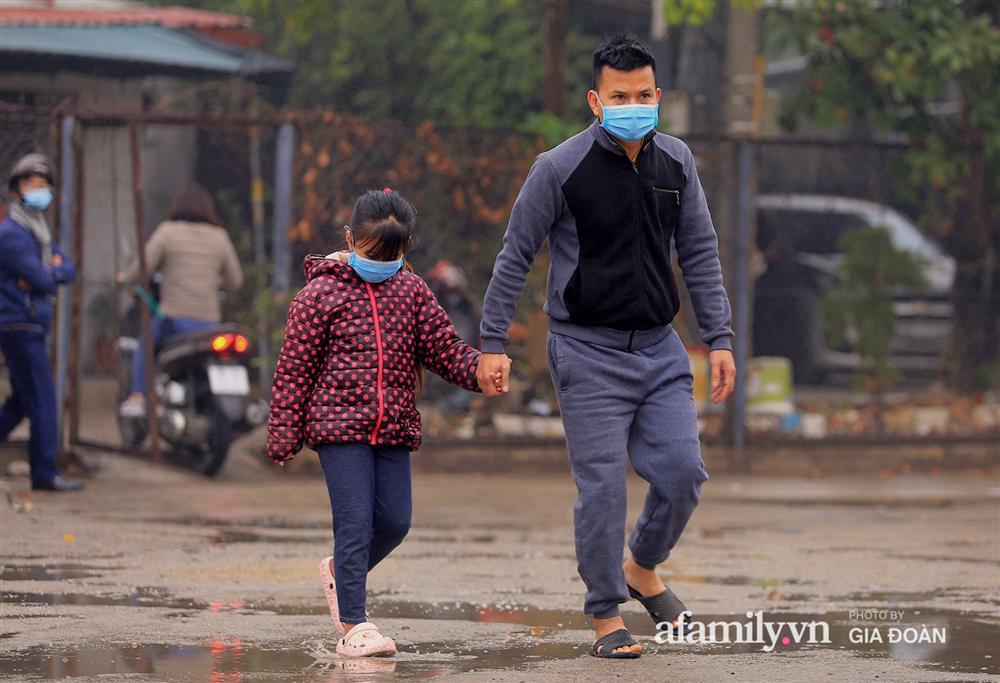 Ảnh: Cha mẹ học sinh trường Tiểu học Xuân Phương đội mưa đưa con đi xét nghiệm COVID-19-2