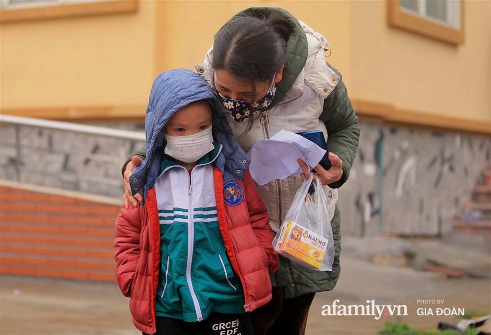 Ảnh: Cha mẹ học sinh trường Tiểu học Xuân Phương đội mưa đưa con đi xét nghiệm COVID-19-3