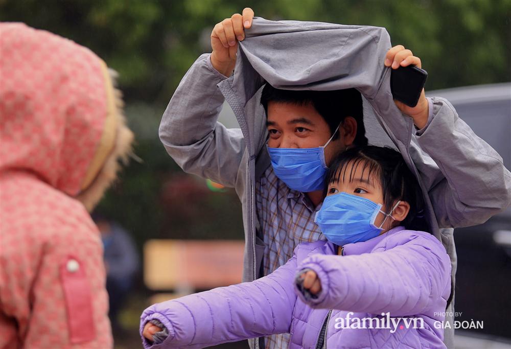 Ảnh: Cha mẹ học sinh trường Tiểu học Xuân Phương đội mưa đưa con đi xét nghiệm COVID-19-4