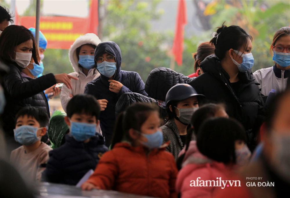 Ảnh: Cha mẹ học sinh trường Tiểu học Xuân Phương đội mưa đưa con đi xét nghiệm COVID-19-10