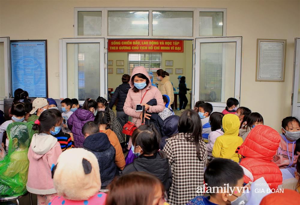 Ảnh: Cha mẹ học sinh trường Tiểu học Xuân Phương đội mưa đưa con đi xét nghiệm COVID-19-11