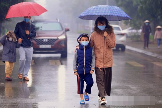 Ảnh: Cha mẹ học sinh trường Tiểu học Xuân Phương đội mưa đưa con đi xét nghiệm COVID-19