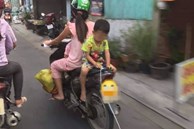 Mẹ để con trai ngồi ngược sau yên xe máy chơi đùa khi đi đường, mặc kệ xe tải chạy sát vách gây phẫn nộ