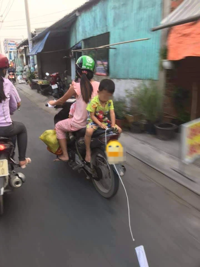Mẹ để con trai ngồi ngược sau yên xe máy chơi đùa khi đi đường, mặc kệ xe tải chạy sát vách gây phẫn nộ-2