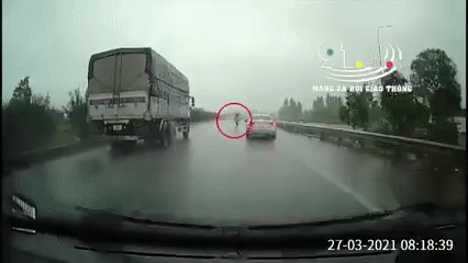 CLIP: Cô gái trẻ bung ô che mưa bất chấp nguy hiểm băng qua cao tốc, cảnh tượng sau đó khiến nhiều người rụng tim-1