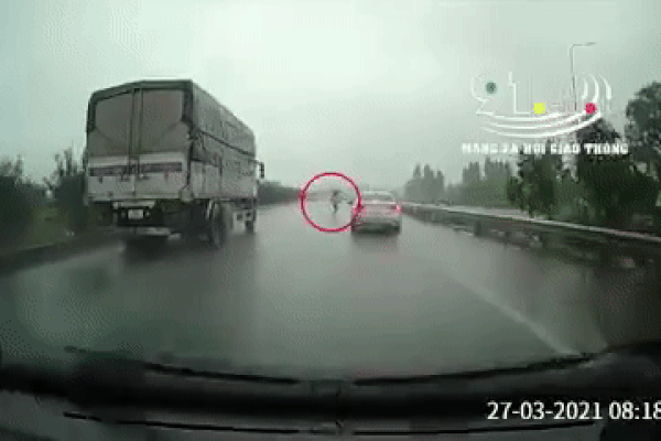 CLIP: Cô gái trẻ bung ô che mưa bất chấp nguy hiểm băng qua cao tốc, cảnh tượng sau đó khiến nhiều người 