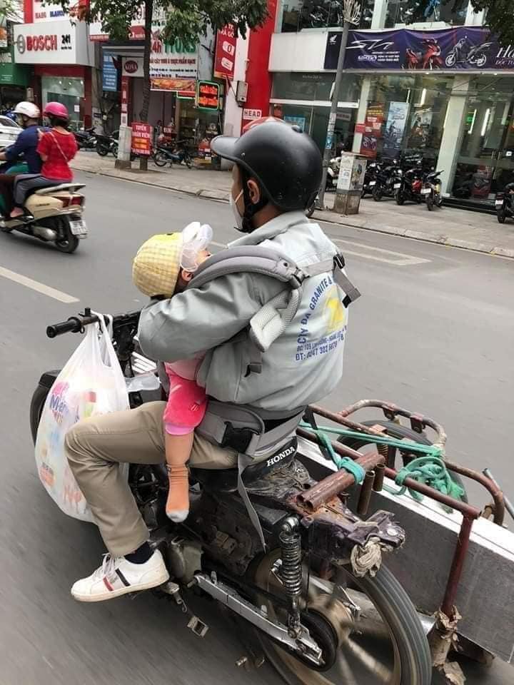 Tranh cãi hình ảnh ông bố chở đồ cồng kềnh vẫn địu con gái trước ngực tham gia giao thông-1
