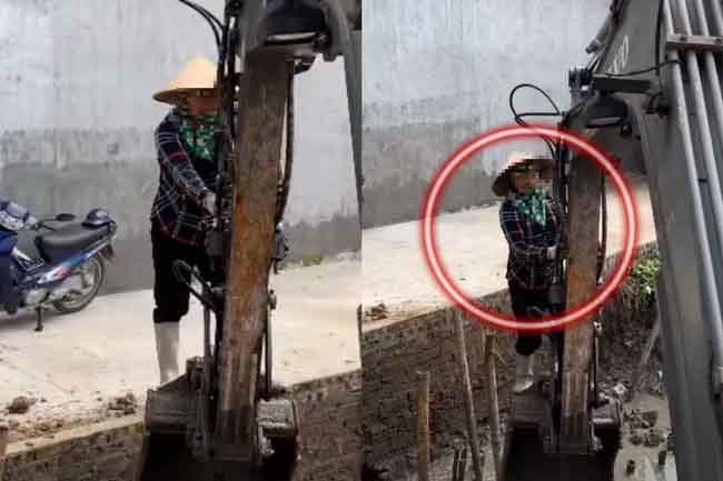 Người phụ nữ đứng cheo leo trên gầu máy xúc cùng tiếng kêu thất thanh khiến ai nấy xem xong đều rùng mình-1