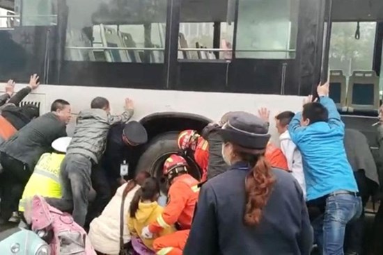 Hàng chục người xô nghiêng xe buýt để giải cứu bé gái bị kẹt chân