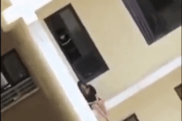 Clip: Thất tình, cô gái ngồi vắt vẻo ở ban công chung cư cao tầng bấm điện thoại, ai nhìn cũng hết hồn?