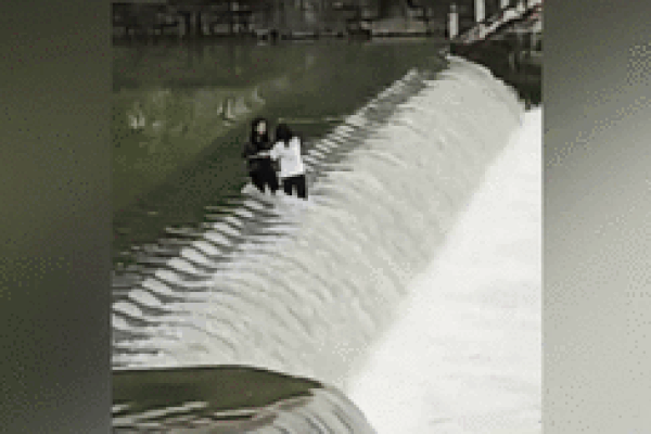 Đứng giữa dòng nước chụp ảnh, 2 cô gái bị cuốn trôi