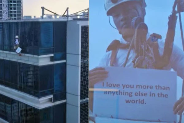 Nhìn ra cửa kính tòa nhà từ tầng 17, cô gái ngạc nhiên khi thấy bạn trai treo lơ lửng, nội dung trên tờ giấy&nbsp;cầm mới bất ngờ!-1