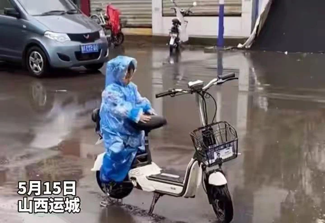 Ngồi trông xe cho mẹ giữa trời mưa, cậu bé có hành động bất ngờ làm bao người lớn tan chảy-1