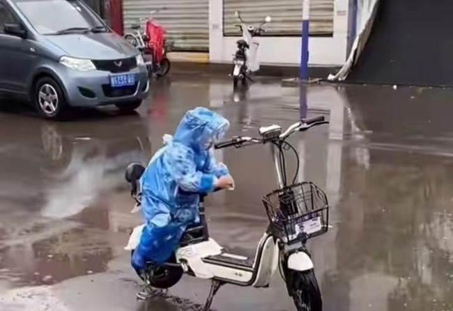 Ngồi trông xe cho mẹ giữa trời mưa, cậu bé có hành động bất ngờ làm bao người lớn tan chảy-2