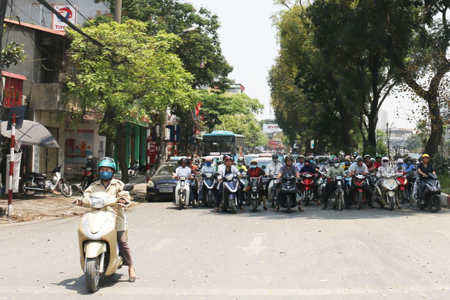 Hà Nội ná thở với cái nóng trên 40 độ, nhiều người tranh thủ núp dưới bóng cây lúc chờ đèn đỏ mà không biết có thể rơi mất tiền!-1