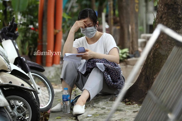 Chiều 7/7: Chùm ảnh phụ huynh ngồi bệt dưới đất, lấy dép kê chân ngồi ngóng trông con thi tốt nghiệp môn Toán-10