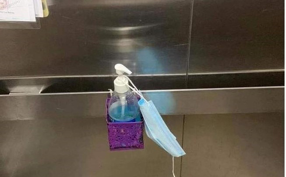 Nam thanh niên khạc nhổ trong thang máy chung cư, lấy khẩu trang lau miệng rồi treo lên lọ nước sát khuẩn-1