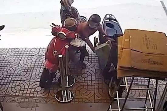Người phụ nữ chở theo 2 bé gái vẫn cố nhoài người bê trộm thùng sữa