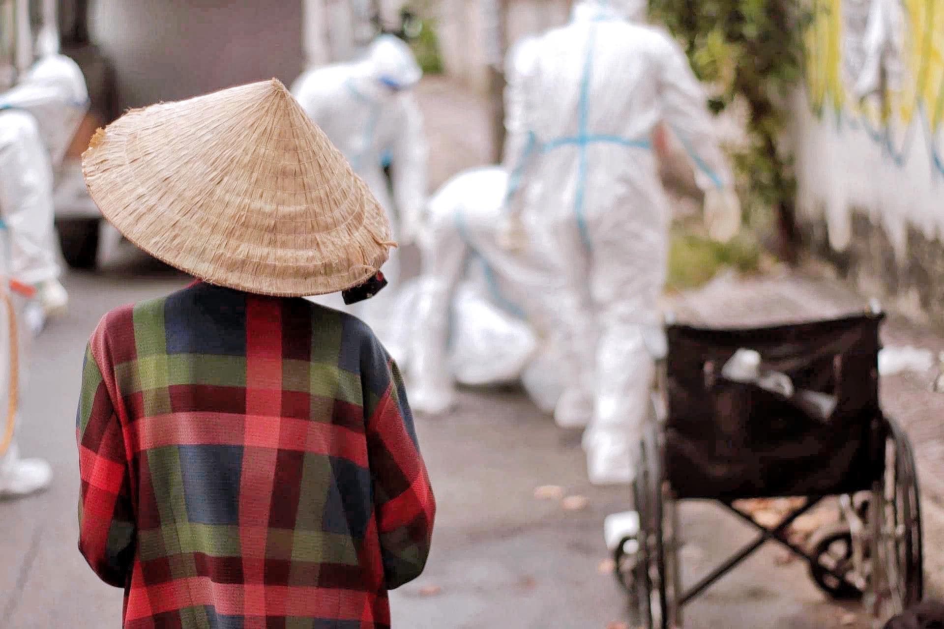 Nghẹn ngào hình ảnh người phụ nữ ở Sài Gòn khóc nấc, lặng lẽ đứng nhìn người chồng vừa qua đời trên chiếc xe lăn được đội cứu trợ đưa về nơi yên nghỉ cuối cùng-2