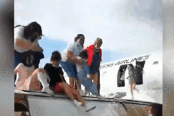 Máy bay trượt khỏi đường băng, hành khách trượt từ cánh xuống đất