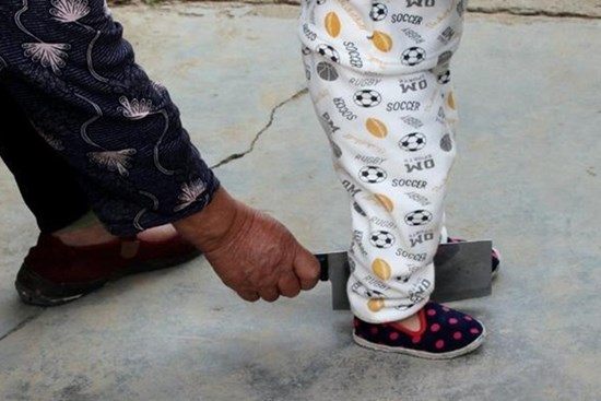 Em bé chập chững tập đi, ông nội đi theo cầm dao chặt phía sau, hành động gây tò mò bắt nguồn từ phong tục trong đám tang