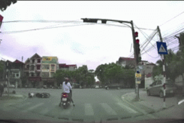 Ô tô tông bay người đi xe máy dừng đèn đỏ giữa trời mưa-1