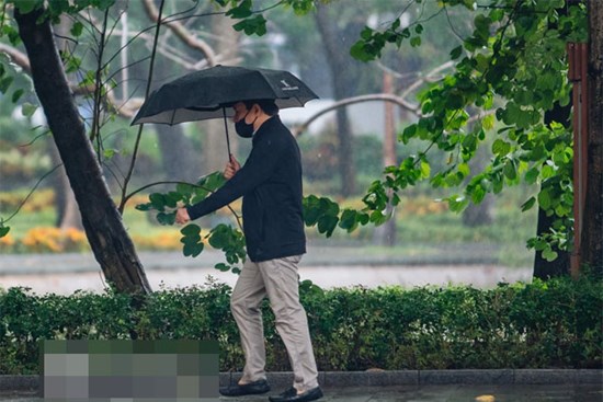 Ảnh: Người Hà Nội co ro trong cơn mưa tầm tã kết hợp không khí lạnh tăng cường