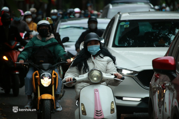 Hà Nội: Không khí lạnh bao trùm sáng đầu tuần, người dân phải mặc thêm áo mưa chống rét dù trời tạnh ráo-9
