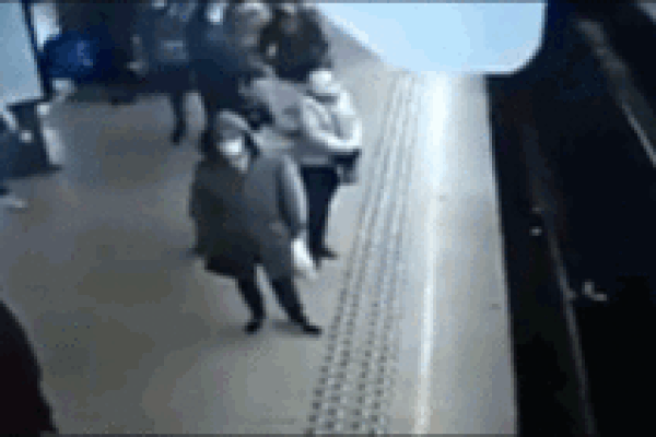 Bị đẩy ngã ngay trước mũi tàu điện ngầm, người phụ nữ may mắn thoát chết khó tin