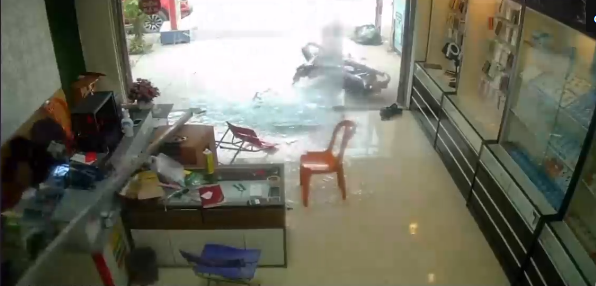 Thanh sắt từ đâu phi thẳng vào cửa hàng điện thoại làm vỡ toang cửa kính, người đàn ông vội ôm đầu nằm xuống đầy kinh hãi-1