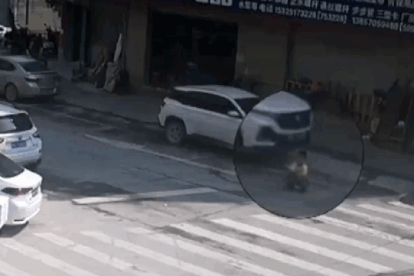 Ngồi chơi dưới đường bị ô tô cuốn vào gầm, cậu bé may mắn không bị thương