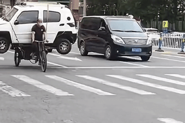 Người đàn ông dùng xe đạp chở nguyên chiếc ô tô con khiến người đi đường ngỡ ngàng