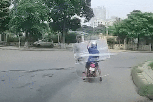 Người đàn ông ôm tivi ngã lăn xuống đường khi xe máy vào cua