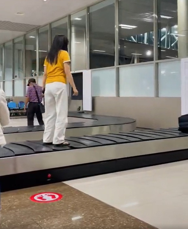 Cô gái mặc áo vàng quần trắng sống ảo trên băng chuyền hành lý-1