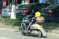 Người đàn ông thả 2 tay, nằm ngửa điều khiển xe máy tại Trung Quốc