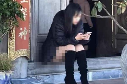 Cô gái mặc đồ ngắn với tư thế ngồi phản cảm khi đang ở cửa chùa