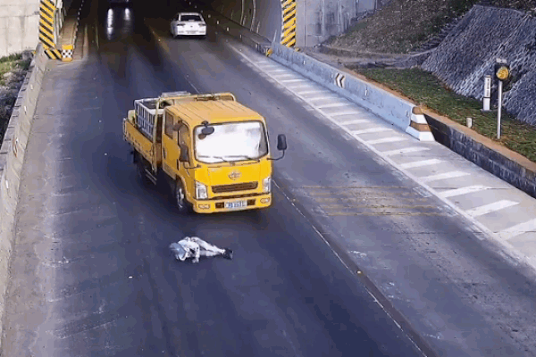 Người đàn ông đứng trên yên xe máy, chạy bon bon trên đường-1