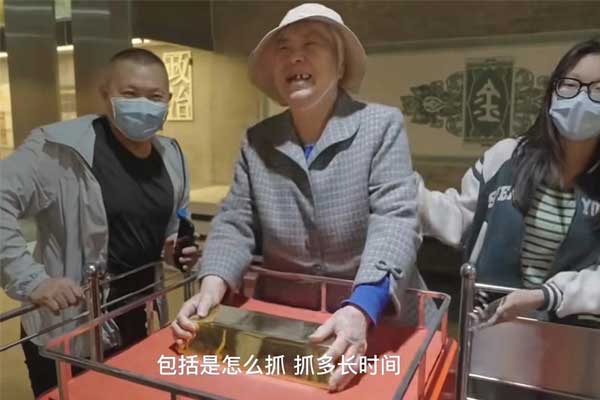 Thử thách nâng vàng 25 kg bằng một tay ở thủ phủ vàng Trung Quốc-1