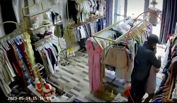 Tên cướp manh động dùng dao khống chế người phụ nữ ở tiệm quần áo-1