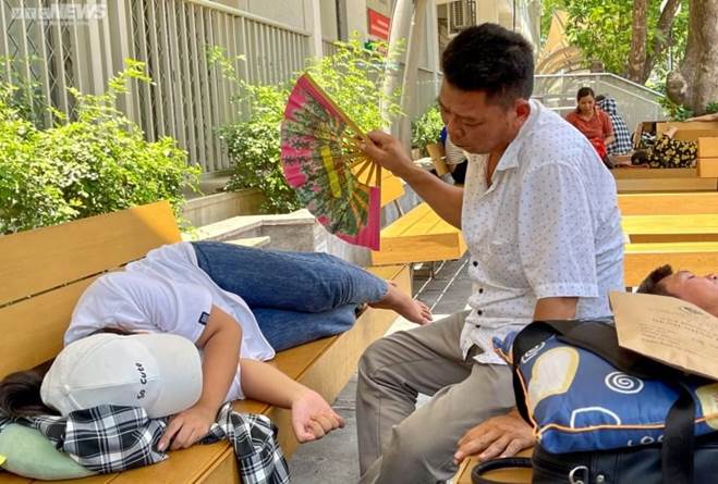 Người nhà bệnh nhân vật vã dưới nắng nóng hơn 50 độ C ở Hà Nội-6