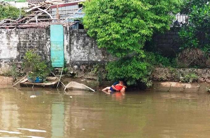 Xót xa cảnh cha ngồi bờ sông ôm thi thể con trai đuối nước-1