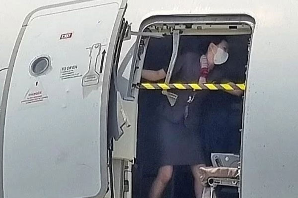 Nữ tiếp viên hàng không che chắn trước cánh cửa máy bay bị mở tung-1