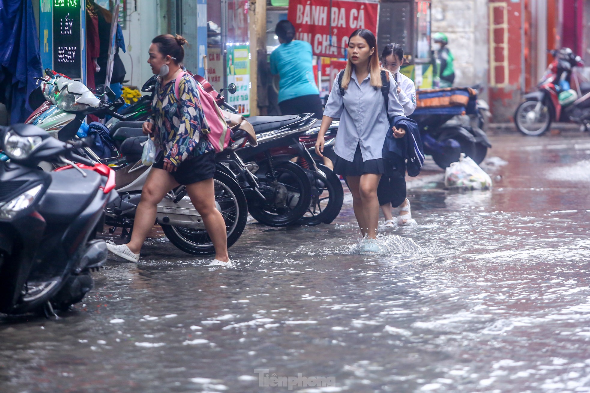 Người dân bì bõm về nhà trên những con phố ngập nước ở Hà Nội-10