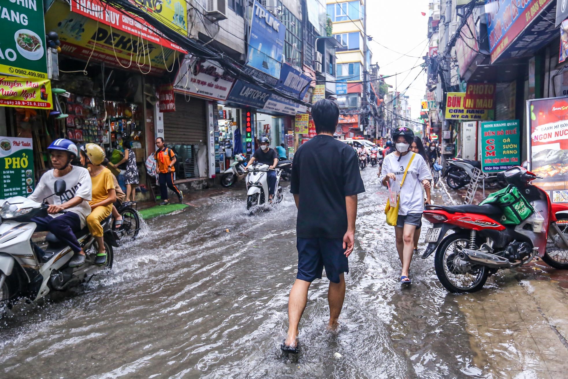 Người dân bì bõm về nhà trên những con phố ngập nước ở Hà Nội-2
