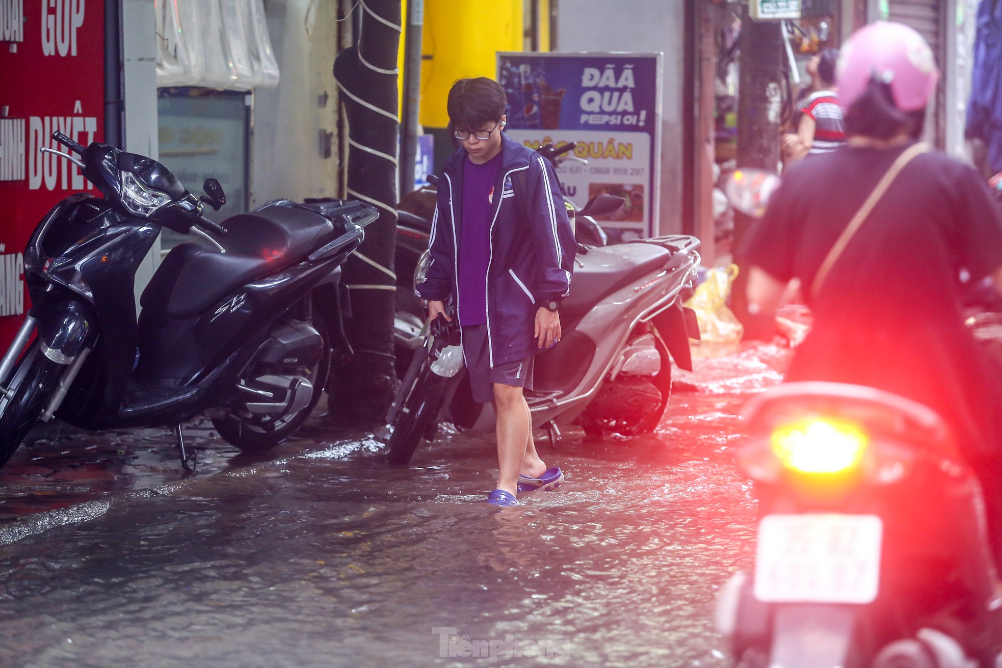 Người dân bì bõm về nhà trên những con phố ngập nước ở Hà Nội-7