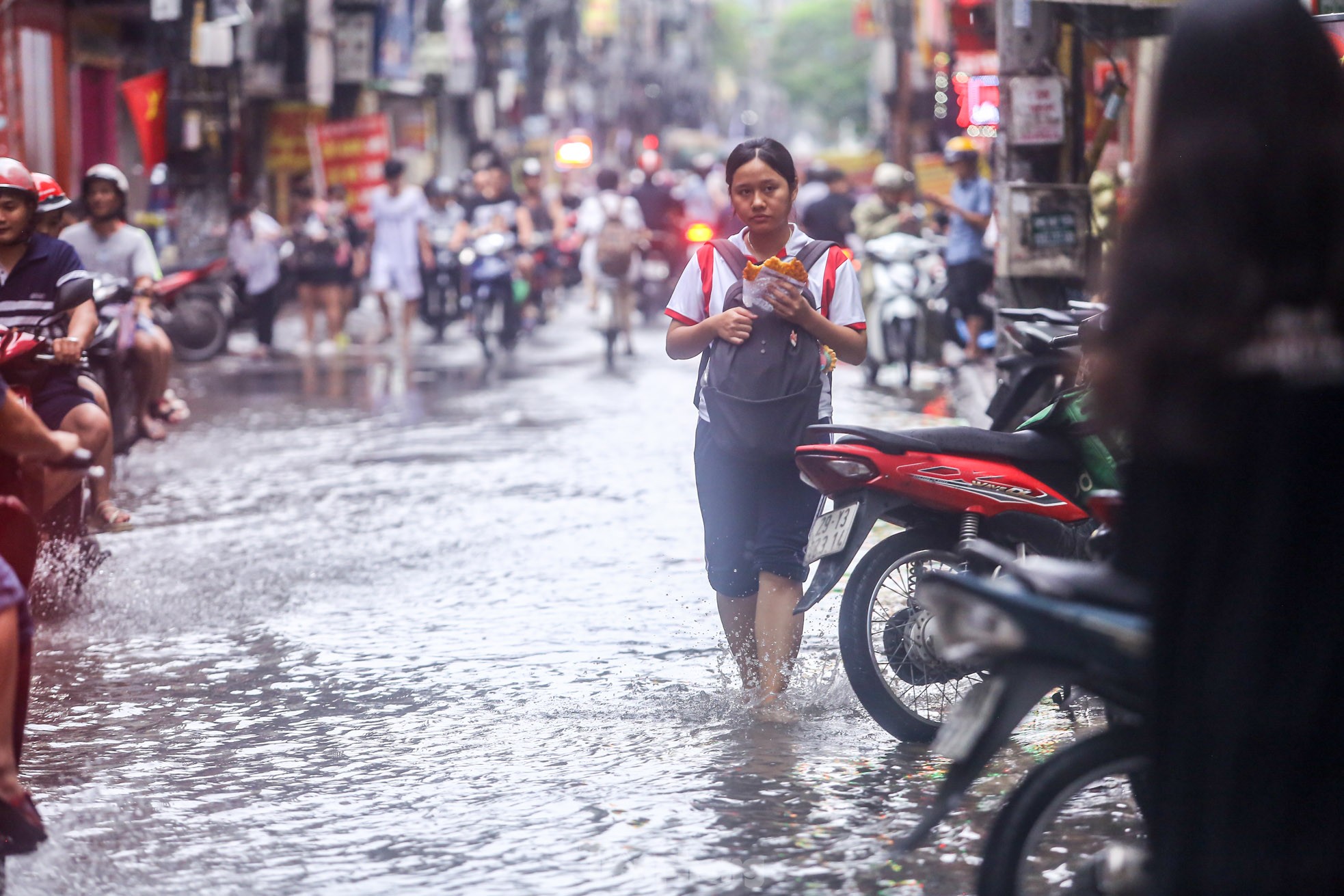 Người dân bì bõm về nhà trên những con phố ngập nước ở Hà Nội-8